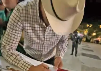 Exhiben a artista firmando bandera de México Exhiben a artista firmando bandera de México
