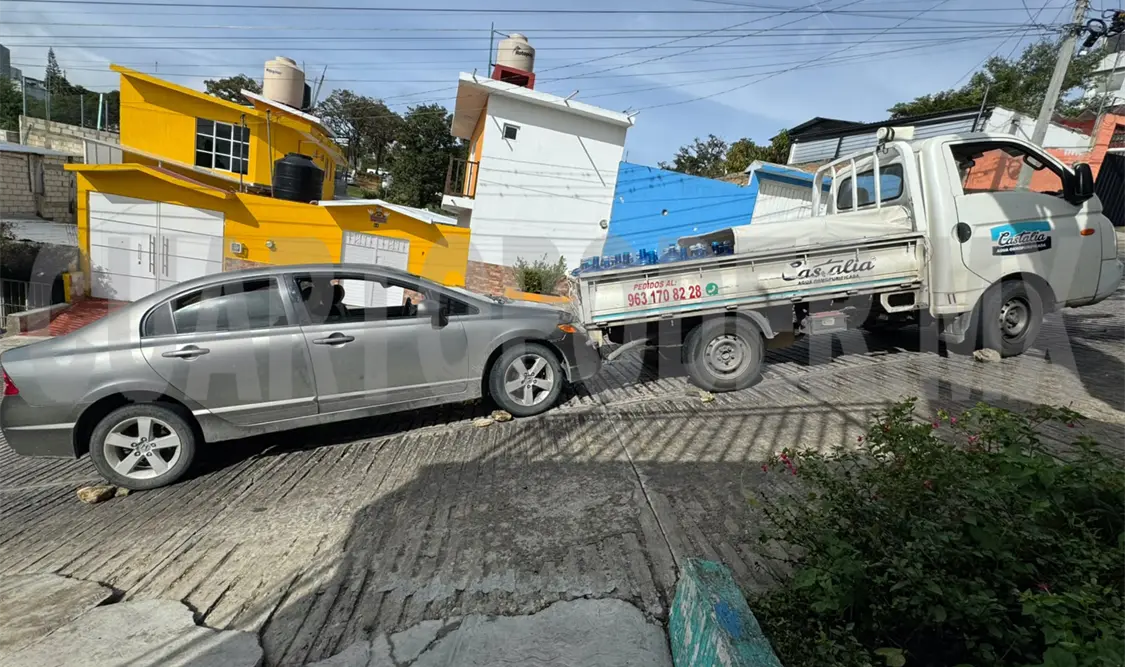 Se va de reversa y embiste a un sedán